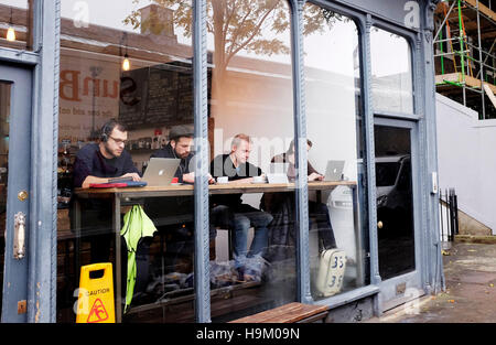 Islington London UK - People using their computers in window of a coffee shop in Islington High Street Stock Photo
