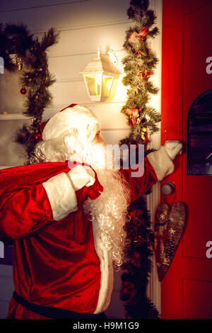 The real Santa Claus. Santa knocks on the door. Christmas night. Stock Photo
