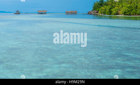 Bay with Underwater Corals in Front of Diving Station and Guesthouses on Kri Island, Raja Ampat, Indonesia, West Papua Stock Photo