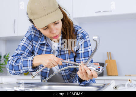 woman plumber fixing a sink Stock Photo