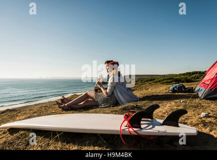 Young couple with surfboard camping at seaside Stock Photo