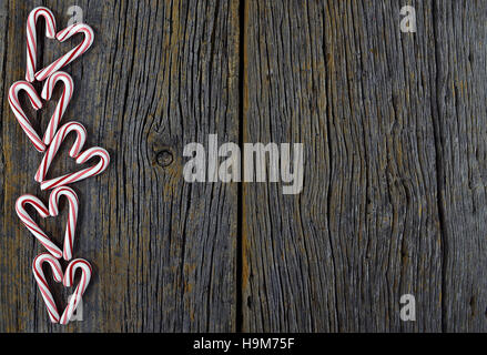 Christmas candy cane hearts on rustic wood Stock Photo