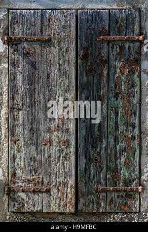 Peeling paint on old wooden window shutters on an old barn in Sarlat in the Dordogne region of France. Stock Photo
