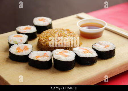 Phtograph of some Sushi roll slices and fried rice on a wood table Stock Photo