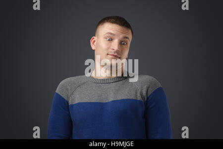 Portrait of a young handsome man who was very much surprised. Emotional photo on black background in studio. Stock Photo