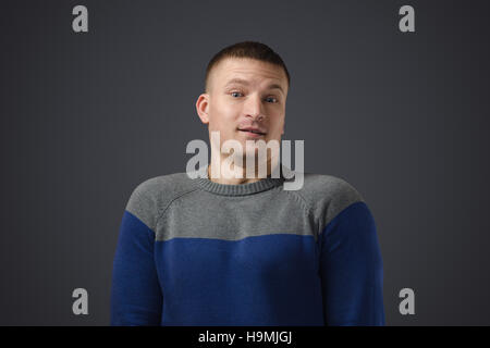 Portrait of a young handsome man who was very much surprised. Emotional photo on black background in studio. Stock Photo