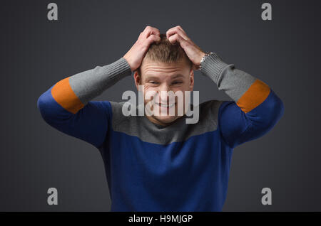 Portrait of a young man who is very aggressive and angry. Emotional photo in studio on a black background Stock Photo