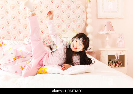 Cute little girl playing on the bed Stock Photo