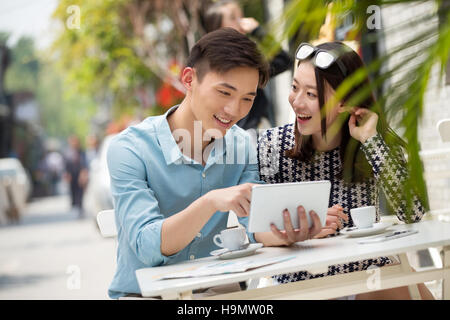 Young couple sitting in a cafe watching Tablet PC Stock Photo