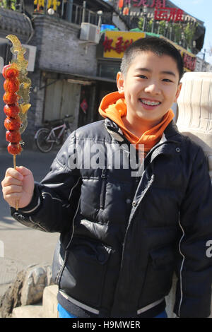 Happy boy holding Tomatoes on sticks Stock Photo - Alamy