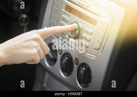 Young smiling lady driver tuning vehicle audio Stock Photo