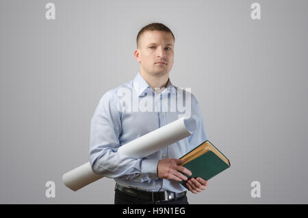 Serious young businessman holding blueprints and architect of the book. On a white background Stock Photo