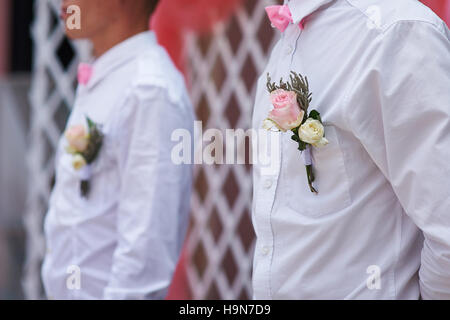 friends of the groom at the wedding ceremony with the buttonhole on the shirt Stock Photo