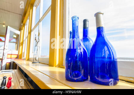 Blue bottles in a window beside the sea, Newfoundland Canada. Stock Photo