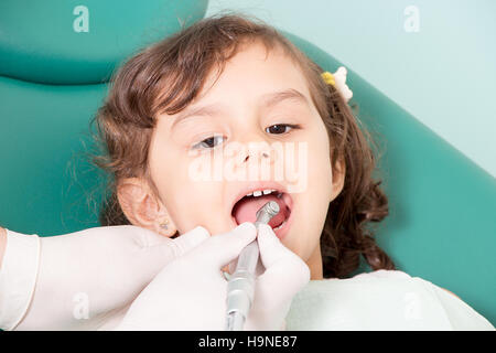 Dentist examining girl's teeth at dental clinic Stock Photo