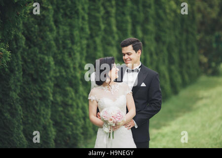 Happy wedding couple walking in a botanical park Stock Photo