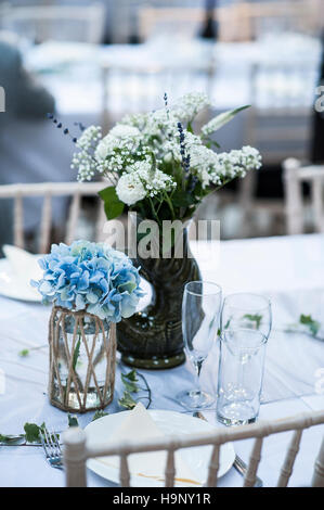 A blue themed set wedding table with flowers in a vase. Stock Photo