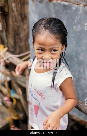 PUERTO PRINCESA,PHILIPPINES-OCTOBER 19,2016: Little girl plays in front of family trade on October 19, Palawan,Philippines. Stock Photo