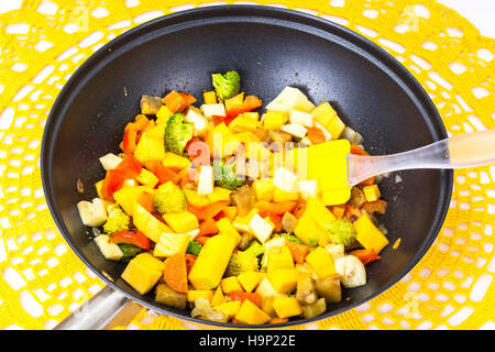 Mix vegetables, stewed in a pan  at home crocheted napkins on a Stock Photo