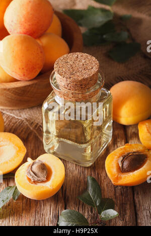 Aromatic apricot oil in a glass bottle close-up on the table. vertical