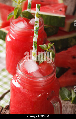 Summer fresh juice of watermelon with ice and mint macro in glass jars. vertical Stock Photo