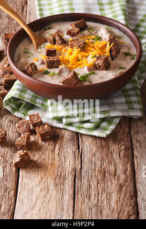 beer soup with sausage, cheddar cheese and croutons in a bowl close-up on the table. vertical Stock Photo