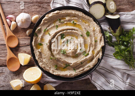 Arabic food baba ghanoush close-up on the plate and ingredients on the table. Horizontal view from above Stock Photo