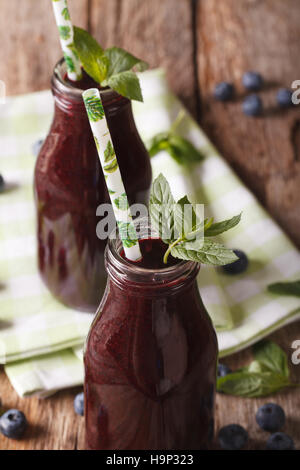 Fresh healthy blueberry juice in a glass bottle on a table macro. vertical Stock Photo