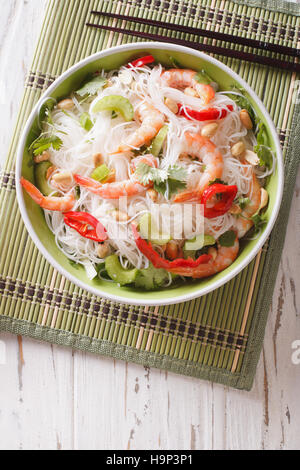 Thai salad with glass noodles, prawns and peanuts in a bowl close-up. vertical view from above Stock Photo