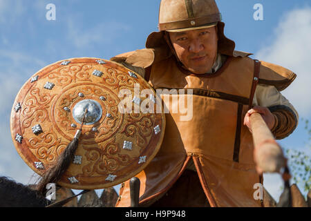 Kazakh man in traditional war outfit with a spear in his hand, at a show of Kazakh national games in Almaty, Kazakhstan Stock Photo