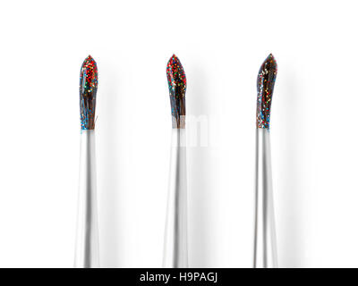 Set of three wet brushes with colored glitters. Isolated on white with clipping path Stock Photo