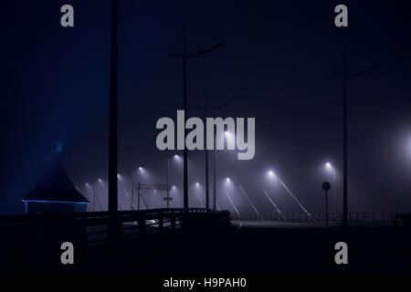 Lights in the fog on the empty night road. Abstract toned night cityscape Stock Photo