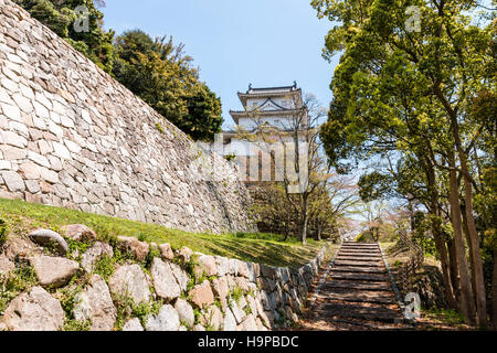 Japan, Akashi castle, AKA Kishun-jo. three-story Hitsujisaru Yagura, turret, atop Ishigaki stone walls. Springtime with blue partly cloudy sky. Stock Photo