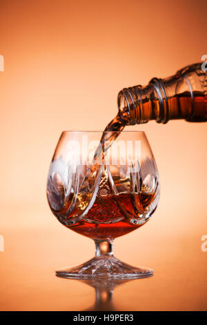 Close up of pouring cognac into glass Stock Photo