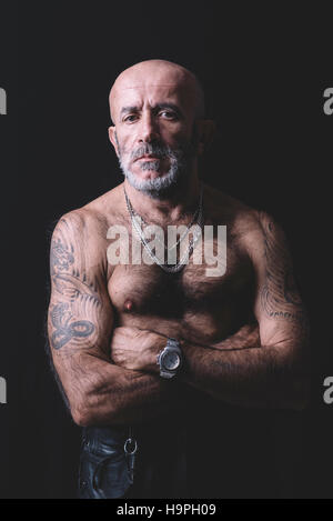 Portrait of bald and tattooed man in low key Stock Photo