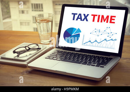 TAX TIME   Business team hands at work with financial reports Stock Photo