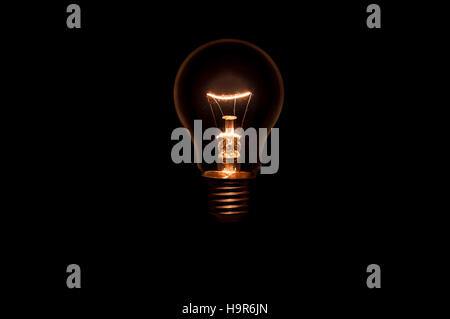 Tungsten light bulb without wiring and socket on black background. Concept for creative idea. Stock Photo