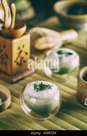 Still life with Japanese matcha accessories and matcha tea latte in small glass bowl Stock Photo