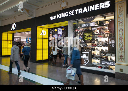 JD sports King of Trainers at INTU Trafford Centre. Manchester. UK   November, 2016. People passing Black Friday 30% Sales Offers Weekend.  City centre holiday shopping season, retail shops, stores, modern, style, bargains, business brands, fashion, advertising, person, consumer, Christmas shoppers, people discount sale shopping, and consumer spending on Black Friday weekend considered to be the biggest shopping event of the year.   U.K. retailers have embraced the U.S. post-holiday sale bonanza, even though many customers were left surprised by wall-to-wall discounts in their favourite stores Stock Photo