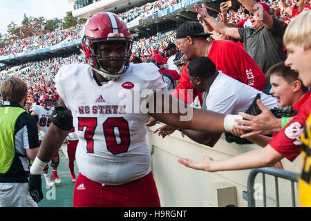 Chapel Hill, North Carolina, US. 25th Nov, 2016. Nov. 25, 2016 - Chapel Hill, N.C., USA - North Carolina State Wolfpack guard Terronne Prescod (70) celebrates with Wolfpack fans after an NCAA football game between the North Carolina Tar Heels and the N.C. State Wolfpack at Kenan Memorial Stadium in Chapel Hill, N.C. N.C. State won the game 28-21. © Timothy L. Hale/ZUMA Wire/Alamy Live News Stock Photo