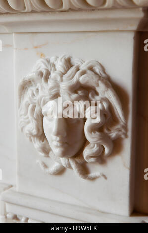 Close view of the carved head of Medusa on the fireplace in the Inner Library at Attingham Park, Shropshire. Stock Photo