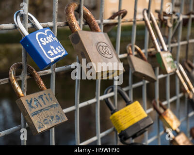 Padlocks attached to a fence on a footbridge over the River Wharfe in Otley, West Yorkshire Stock Photo