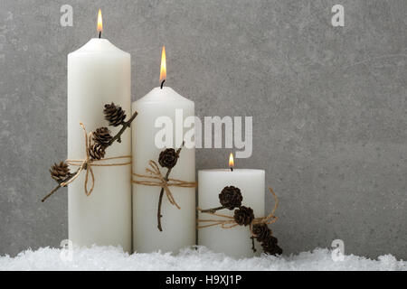Burning White christmas candles on concrete, background Stock Photo