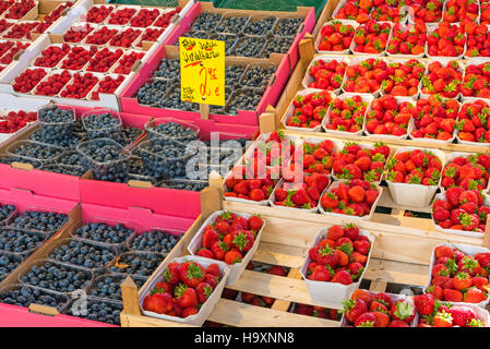 Strawberries, blueberries and raspberries for sale at a market Stock Photo