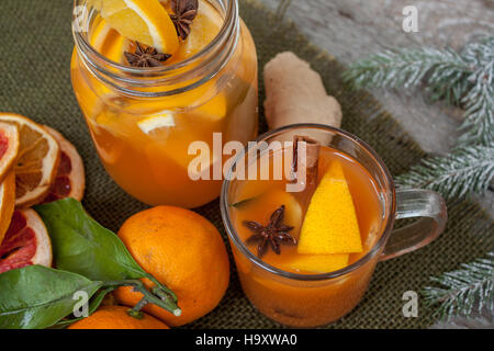 Winter healing ginger drink with lemon, honey and oranges. Cinnamon, star anise, fir twigs, tangerines, dried grapefruit. Winter christmas background, Stock Photo