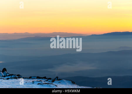 Golden sky and stunning sunset in wintry mountain, romantic background for postcard or wallpaper Stock Photo