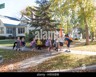 Young children lining up behind school patrol to guide them across street. St Paul Minnesota MN USA Stock Photo