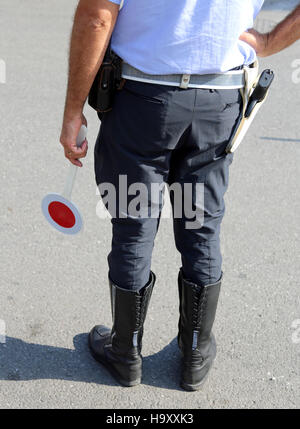 policeman with guns and paddle traffic on the street in checkpoint Stock Photo