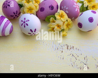 Violet Easter eggs and primrose flowers bouquet composition Stock Photo