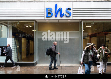 Exeter, England, UK - 22 November 2016: Unidentified people walk by permanently closed BHS shop on Fore Street. Stock Photo